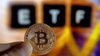 a person is holding a bitcoin in front of the etf sign