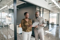 two business people looking at a tablet in an office